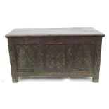 An oak coffer, with plain rising lid and three carved panels to the front,