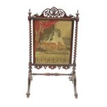 A 19th century rosewood fire screen, with fret cut top frieze, raised on a turned column support,