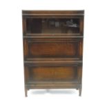 A Globe Wernicke three section bookcase, with a glazed slide over two fielded panel slides,