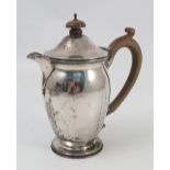 A silver hot water jug, of bulbous form, with wooden handle and finial, London 1929, gross weight 8.