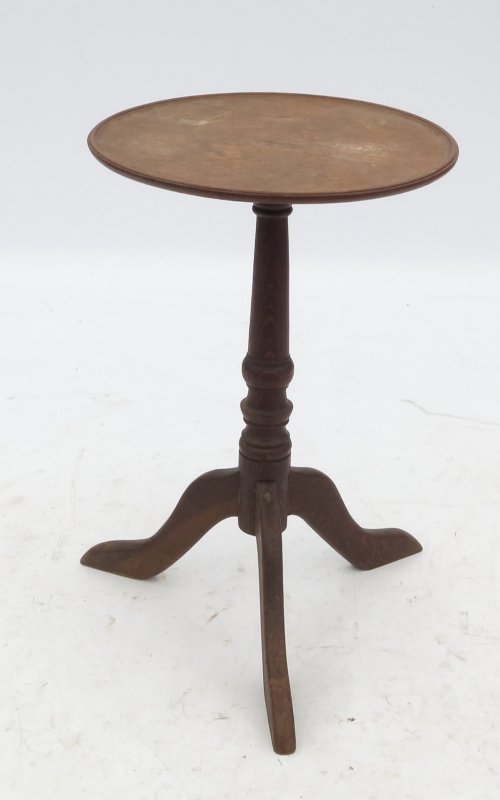 A 19th century oak circular table, the dish top raised on a tripod base,