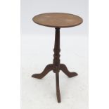 A 19th century oak circular table, the dish top raised on a tripod base,