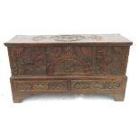 A heavily carved elm mule chest, having a carved rising lid,
