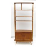 An Ercol display unit, having four open shelves above a cupboard base,