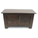 An Antique oak coffer, with plain rising lid and carved panels to the front,
