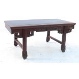 A low Chinese hardwood opium table, raised on slightly outswept legs with carved frieze,