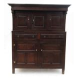 An 18th century oak deudarn, the upper section fitted with three fielded panel cupboard doors,