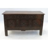 An Antique oak coffer, in the Dorset style, having carved frieze over three carved panels,