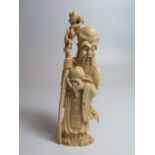 A Chinese Carved Ivory Figure of a Sage holding gourd and staff, 15cm