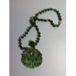 A Carved Jadeite Pendant on bead necklace