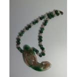 A Chinese Carved Jade Pendant on bead necklace