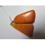 A Baltic Amber Pendant, c. 50mm long, 10.8g and one otherA Baltic Amber Pendant, c. 50mm long, 10.8g