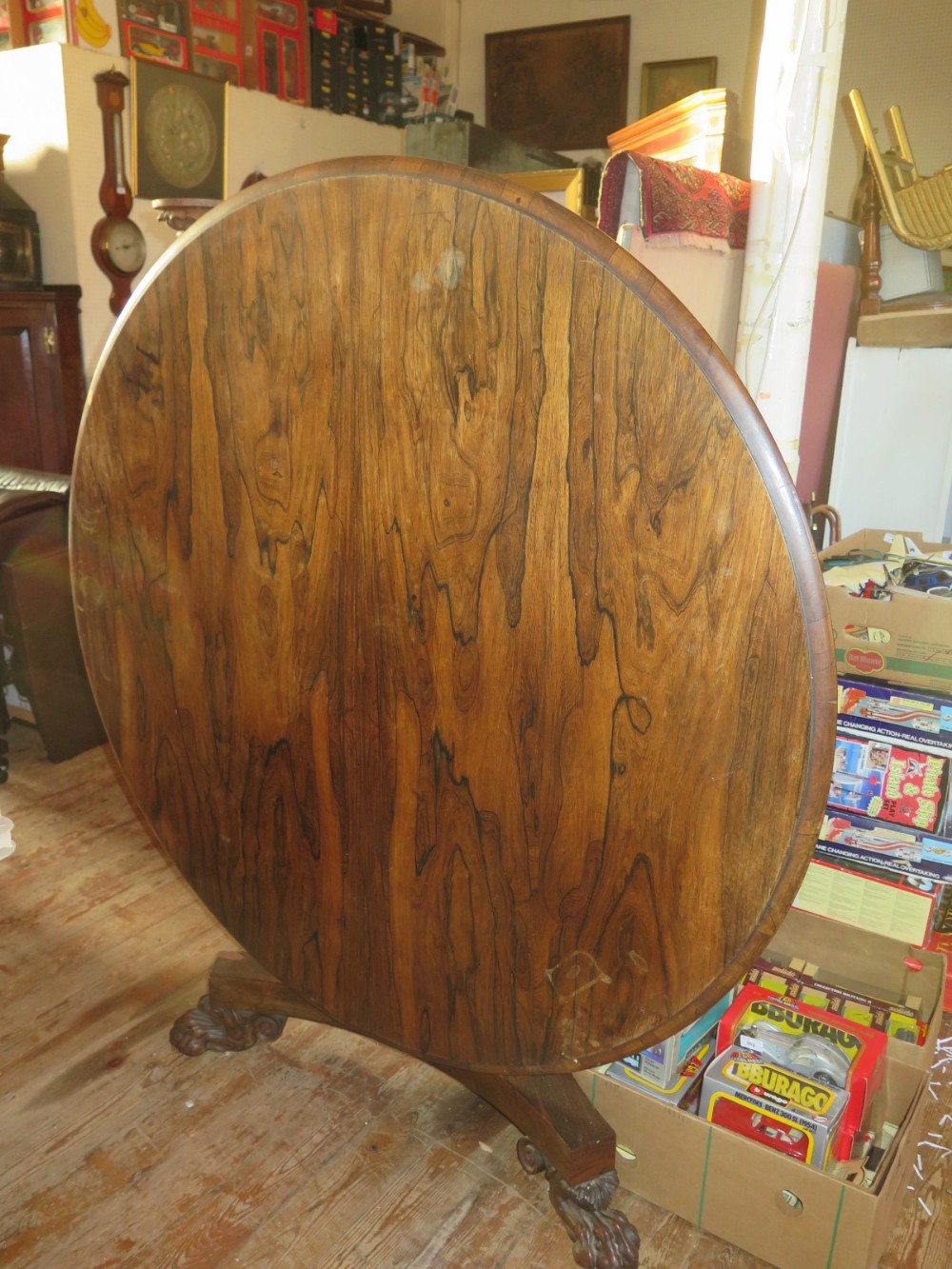 A Large Early Nineteenth Century Rosewood Tilt Top Dining Table raised on single pedestal with