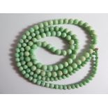 A Chinese Jade Necklace of pale green beads (largest c. 9mm), 145g, 104cm