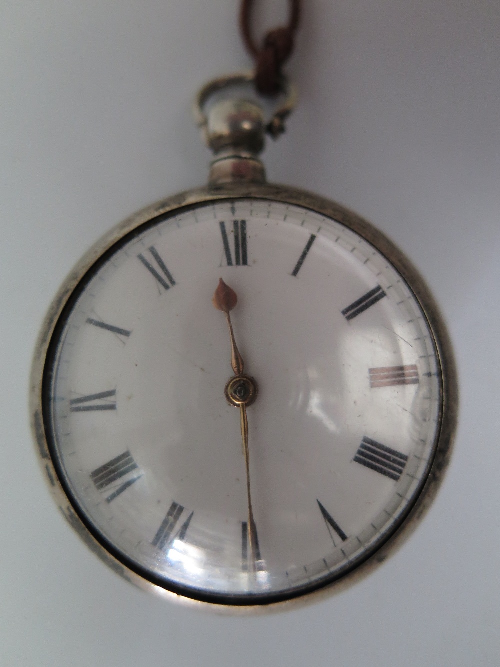 A George IV Silver Pair Cased Pocket Watch, the enamelled dial with Roman numerals, the single chain