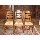 A Set of Six Brights of Nettlebed Oak and Rush Seated Ladder Back Chairs including two carvers