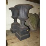 A Pair of Cast Iron Garden Urns on Plinths, 68 cm high