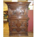 A Nineteenth Century Heavily Carved Oak Cupboard decorated with six panelled tavern scenes including