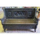 A Victorian Oak Heavily Carved Bench with lift up seat decorated with scene of courting couple,