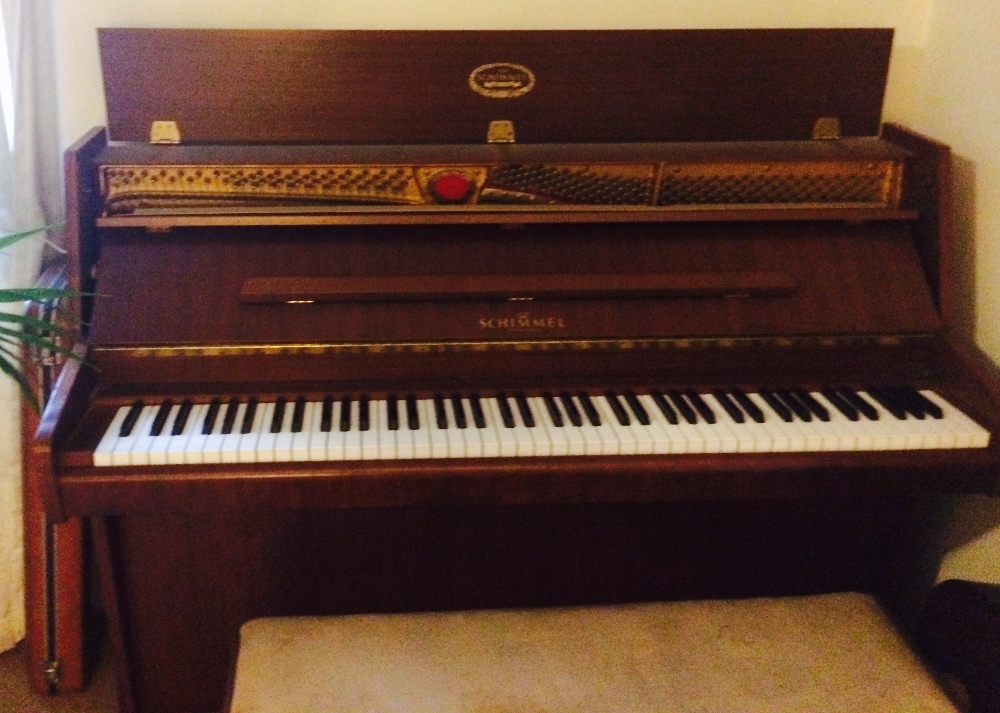 Schimmel (c1983) 
A modern style upright piano in a mahogany case together with a duet stool.