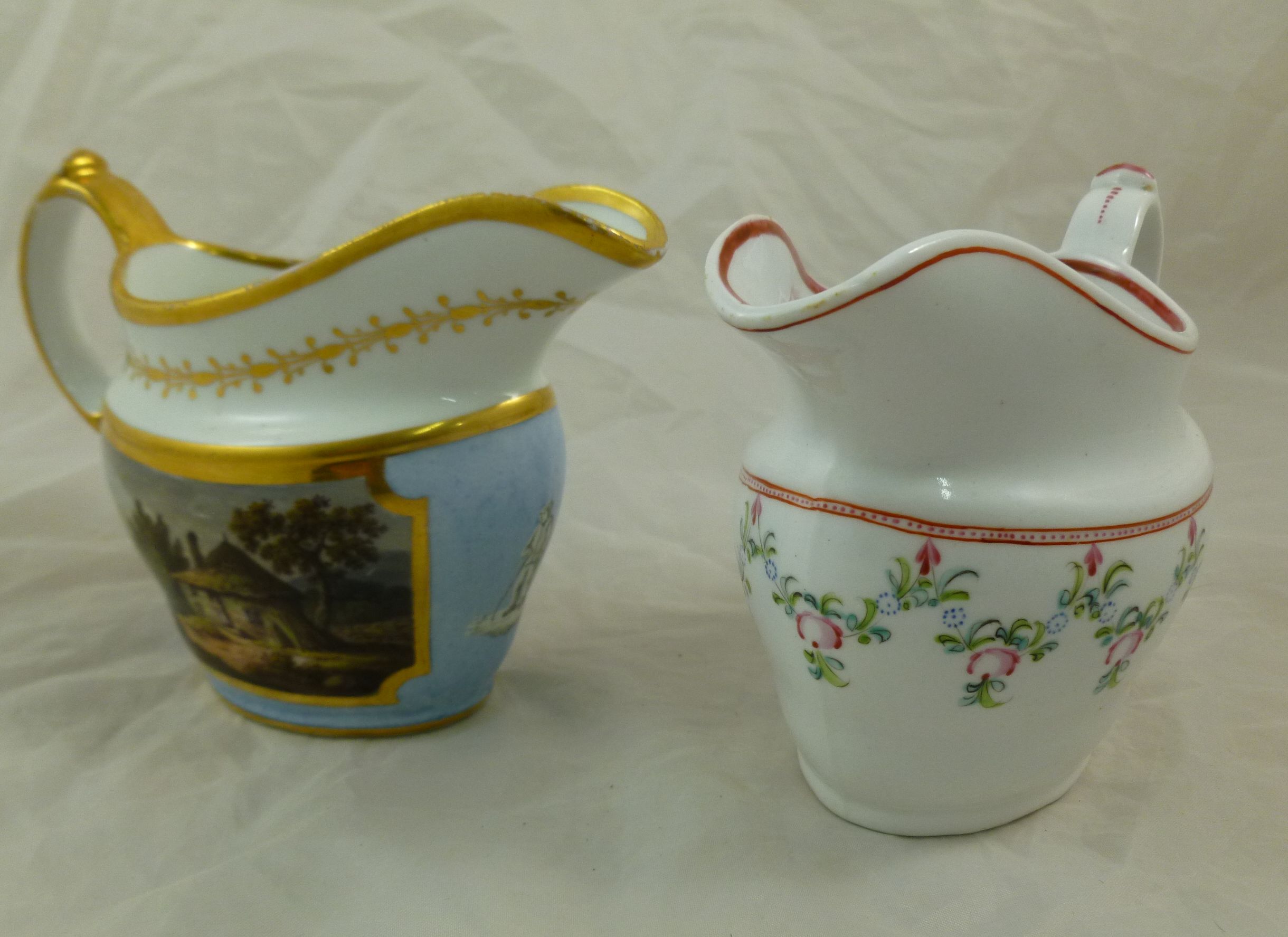 Two late 18th/early 19th century porcelain milk jugs, the first decorated with hand painted rural