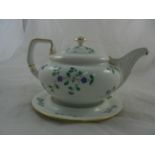 A Derby porcelain teapot and stand decorated with hand painted trailing blule flowers,