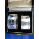 A pair of silver heavy gauge napkin rings of oval form with engine turned decoration,