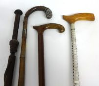 Four walking canes including vertebra, tribal and silver mounted
