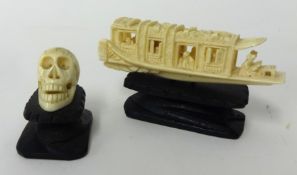 Miniature carved bone skull on wood plinth also small carved bone model of a Chinese boat in