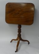 A 19th century mahogany snap top tripod table on small brass castors