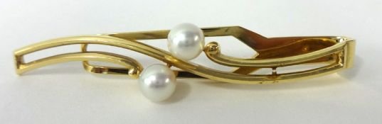 A Mikimoto gold brooch set with two pearls, stamped 'K.Mikimoto, Tokyo, K14' in original box