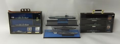 Collection of various model ships arranged in four cabinets