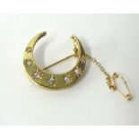 Yellow metal crescent brooch set with seven diamonds, approximately 30mm wide