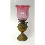 Brass oil lamp with cranberry glass shade, 45cm