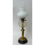 Brass oil lamp with glass reservoir and milk glass shade, 61cm