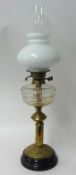 Brass oil lamp with glass reservoir and milk glass shade, 61cm