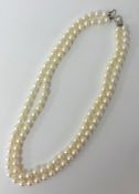 A Mikimoto set of two strand pearls with original silk case and box