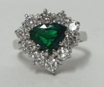 Emerald and diamond heart shaped cluster ring central cut heart cut central emerald surround by