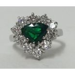 Emerald and diamond heart shaped cluster ring central cut heart cut central emerald surround by