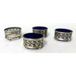 Set of four silver pierced table salts, three with blue glass liners (4)