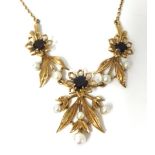 A 9ct gold, garnet and pearl set necklace on fine chain of flower and leaf design