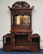 A Chinese cabinet, carved throughout with stylised  bamboo planets, water lilies and dragon's,