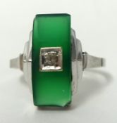 An Art Deco style ring set with diamond and green hardstone in white metal