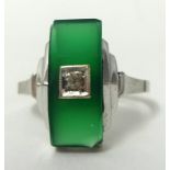 An Art Deco style ring set with diamond and green hardstone in white metal