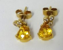 Pair of 18ct gold stud earrings each with rub over trefoil setting with yellow sapphires and