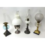 Four various Victorian and later oil lamps, tallest 63cm