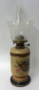 A Victorian oil lamp, Doulton, decorated with flowers, with brass Hink & Sons burner, etched glass