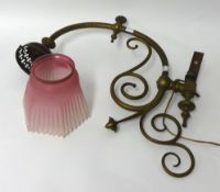 A Victorian ornate brass wall light bracket together with a pink coloured glass shade with crimped