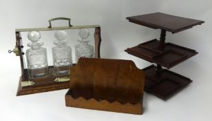 A three bottle glass decanter Tantalus in oak case, a small pipe rack and stand