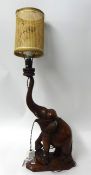 An Indian carved hardwood table lamp in the form of an elephant, (wood 56cm high)